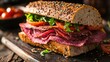 © Nany - A delicious deli-style roast beef sandwich with tomato slices and arugula on a seeded bun.