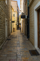 Narrow historic alley with stone buildings in Mediterranean old town. Cultural heritage, summer tourism, and urban charm