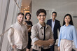 © fizkes - Armenian businesswoman and diverse employees posing for photo standing together in corporate workspace, exuding confidence, competence and professionalism. Company staff members portrait. Partnership