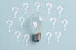 © tonstock - Innovation and insight drive problem solving and decision making symbolized by a glowing bulb surrounded by question marks