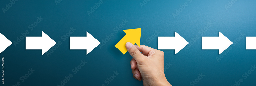 Group of arrows in one direction and businessman hand holding arrow ...