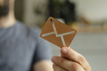 Aufkleber - Close-up of a person's hand holding a small cardboard cutout of an email symbol.  Perfect for communication concepts.