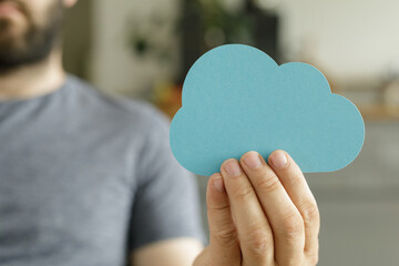 Leinwandbilder - Image of a person holding a paper cloud, symbolizing cloud computing, storage, and data.