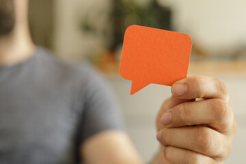 Poster - A man holds an orange speech bubble, representing communication and feedback.