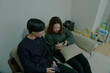 © maru54 - 部屋でスマートフォンを操作する若い恋人たち