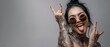 © Inna - The confident woman with tattoos and sunglasses expressing joy and attitude