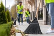 © Aleksandr - Community cleanup crew sweeping sidewalk on a sunny day