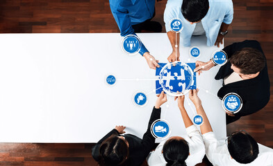 Fototapete - A diverse team collaborates at a modern office table, analyzing puzzle pieces representing various business strategies, highlighting teamwork and effective problem-solving techniques. Amity