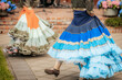 © Emvats - Close-up of dancers in traditional, colorful layered skirts during a lively folk performance, highlighting motion and ornate costume details.