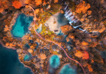 Wall Mural - aerial view of waterfall in red autumn forest at sunrise. morning in plitvice lakes park, croatia. c