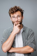 Aufkleber - Pensive Man With Glasses Touching Chin Against Grey Backdrop, Representing Contemplation and Problem Solving for Business Insight and Creative Thinking : Generative AI