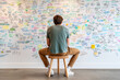© Alina - Entrepreneur brainstorming ideas in a creative workspace with colorful notes on the wall