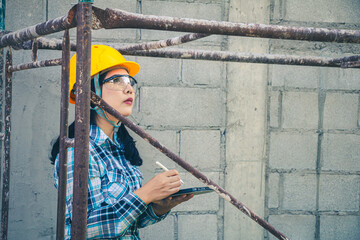 Wall Mural - Young female project manager supervising construction work at residential building project.
