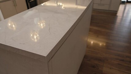 Poster - Modern kitchen island with white marble countertop, minimalist design, warm lighting, and neutral cabinets for bright
