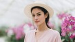 © Pro Hi-Res - Model poses gracefully among blooming orchids in a greenhouse during daylight.