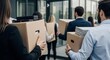 © JUN LI - Employees are holding boxes containing their personal belongings, illustrating the concept of corporate layoffs and termination of employment relationships