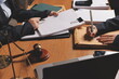 © Kansuda - Attractive young lawyer in office Business woman and lawyers discussing contract papers with brass scale on wooden desk in office. Law, legal services, advice, Justice and real estate concept.
