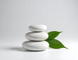 © benkurr - Balanced River Stones with Green Leaf – Zen Still Life Composition on White Background