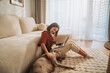 © Big Shot Theory - A woman works on her laptop at home, enjoying a cozy moment with her dog
