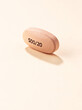 © ADDICTIVE STOCK - Pink oval pill with imprinted numbers on smooth surface