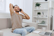 © SHOTPRIME STUDIO - Happy man talking on the phone in a modern living room, wearing casual clothes, enjoying a cheerful moment, surrounded by plants and natural light.