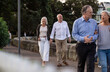 © Austockphoto - Senior couples walking along the paved pathway.