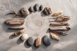 © Yurii Semonov - Flatlay of smooth river stones, driftwood, and dried plants in circular layout