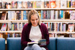 © Austockphoto - Young Australian woman in her twenties in library reading a fiction book