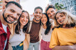 © Davide Angelini - Happy group of friends smiling at camera outside - Diverse young people having fun together on city street - Youth community and people life style concept