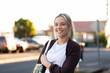 © Austockphoto - portrait of smiling twentysomething Australian woman with tote bag in urban area late in the day