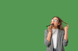 © Pixel-Shot - Young beautiful woman with mobile phone sending voice message on green background