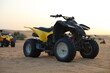 © Liliia - Yellow quad bike parked in desert at sunset. Black quad bike standing alone on desert sand