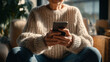 © Svante Berg - Senior Hands Holding Smartphone Using Mobile Technology in Warm Sweater Indoors