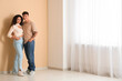 © Pixel-Shot - Young couple near beige wall in their new flat