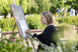 © castenoid - The young woman sketching a floral composition with a pencil during a plein air session