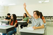 © AntonioDiaz - Hispanic high school student raising hand in classroom during lesson