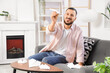 © Pixel-Shot - Young man with paper plane sitting on sofa in office