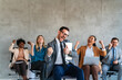 © NDABCREATIVITY - Excited overjoyed diverse business people, team celebrate corporate victory together in office