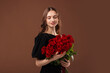 © New Africa - Smiling woman with bouquet of roses on brown background