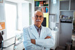 © Davor - Portrait of a confident senior male doctor standing in a bright office with arms crossed