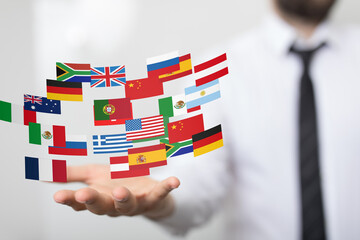 Poster - Image of a hand holding various national flags, symbolizing international business and global connections.