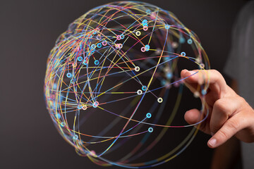 Poster - Abstract image of a hand interacting with a colorful network sphere, representing global connections and communication.