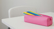 © Melissa - Pink pencil case with colored pencils on white table