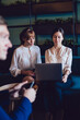 © BullRun - Female executives in formal wear analyzing program on laptop together at lobby of business center