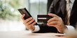 © Daenin - Close-up of a man filling in credit card information on a smartphone to complete a payment transaction. Online shopping, payment, login.