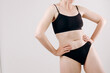 © Kateryna Muzhevska - Woman in black sportswear poses confidently against a neutral background, showcasing fitness and body positivity in a minimalist setting