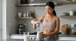 © Николай Срибяник - Active woman is pouring milk into a blender in a contemporary kitchen, preparing a nutritious smoothie, reflecting a healthy lifestyle and dedication to fitness