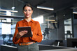 © Stock 4 You - Latin Hispanic mature adult professional business woman looking at online trade app. European businesswoman CEO holding digital tablet using fintech tab application standing at workplace in office.
