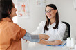 © Home-stock - Happy young woman doctor measuring blood pressure of female patient, using medical electronic measurement device