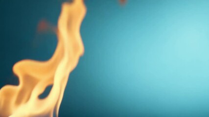 Aufkleber - Fiery Essence: A close-up shot of a vibrant, yellow-orange flame dancing against a striking turquoise background, depicting power and energy.